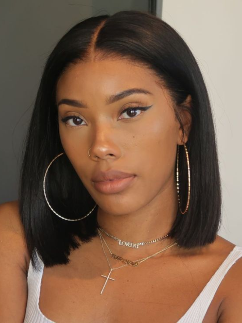 A model displays the UNice Bye Bye Knots Wig 7x5 Put On And Go Glueless Lace Bleached Knots Bob, showing a model with long black hair wearing a white top and gold hoop.