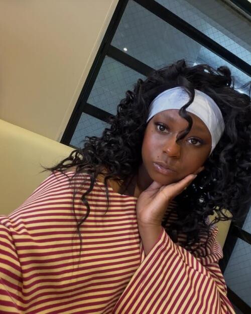 Curly headband wig worn by a Black woman with a white headband