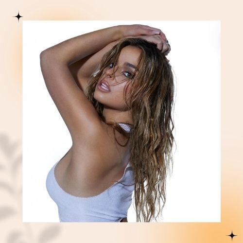 Addison Rae featuring wet-look styled hair posing in a white top