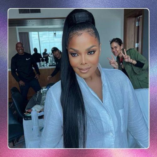 Janet Jackson in a light blue shirt with a sleek high ponytail hairstyle