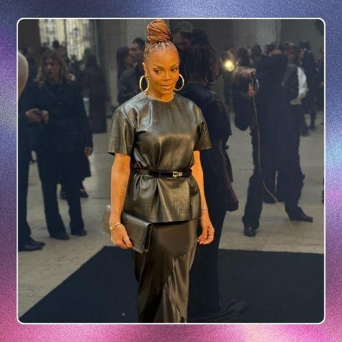 Janet Jackson on the red carpet in a black leather outfit with a high braided bun hairstyle