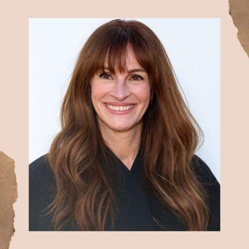 Julia Roberts smiling with long dark brown hair and thick front bangs