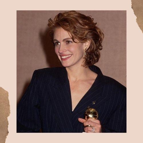 ulia Roberts with a chic short wavy haircut wearing a navy dark suit jacket