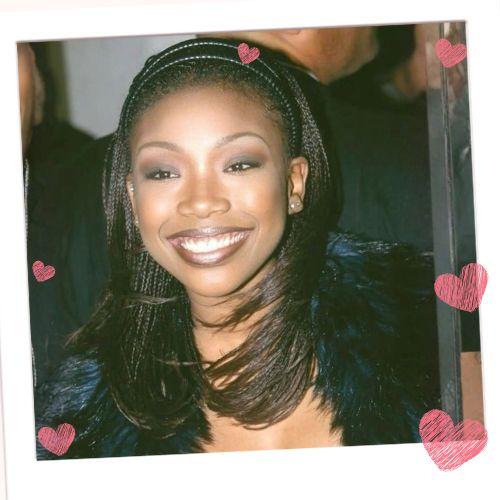 Brandy Norwood wearing her iconic '90s micro braids layered naturally with a dark headband