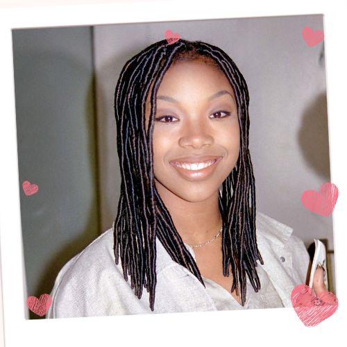 Brandy Norwood smiling with shoulder-length dark rope twists parted neatly down the middle