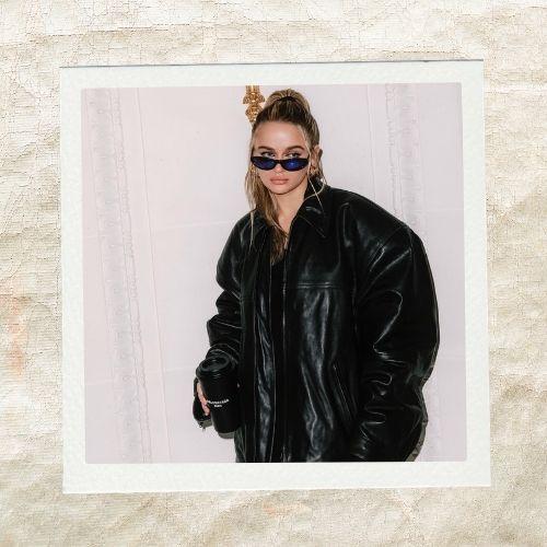Joey King wearing a black leather jacket and sunglasses with a high half-ponytail