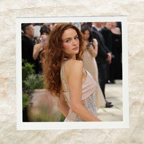 Joey King looking back on the red carpet showcasing voluminous wavy reddish-brown hair