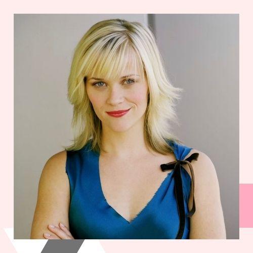 Reese Witherspoon with a bright blonde layered bob haircut and full bangs
