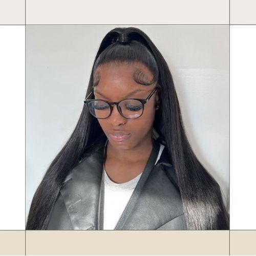 Woman with sleek half-up half-down long black hair wearing glasses and a black jacket