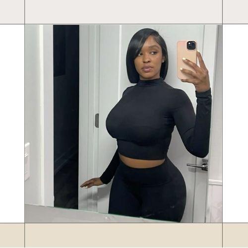 Woman taking a full length mirror selfie with a sleek side-parted short black bob hairstyle