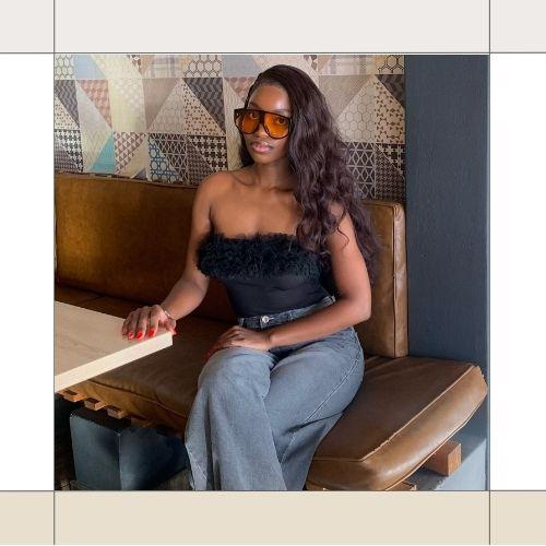 Woman with long soft beach waves hair wearing a tube top sitting in a restaurant