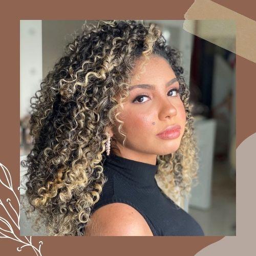 High-volume natural curly hair featuring blonde ribbon highlights