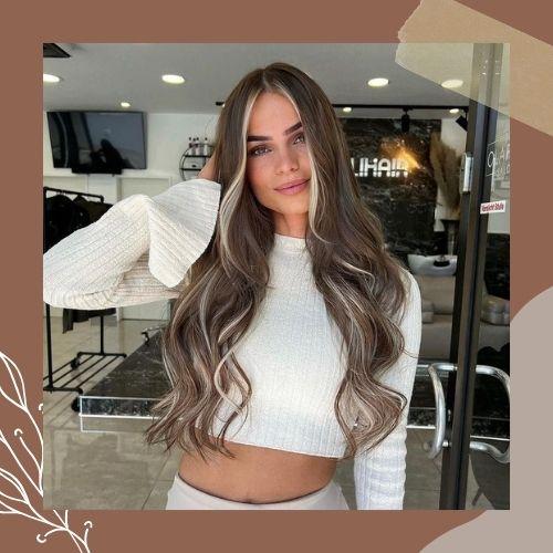 Long brown hair with blonde face framing ribbon highlights and soft waves