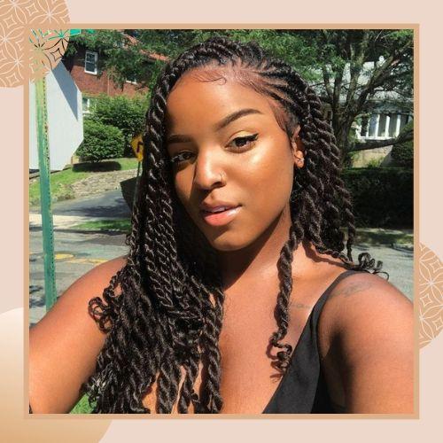 Side-swept two-strand twist hairstyle draped over one shoulder