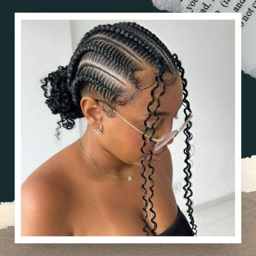 A close-up profile of a woman with a cornrow updo hairstyle and loose face-framing strands.