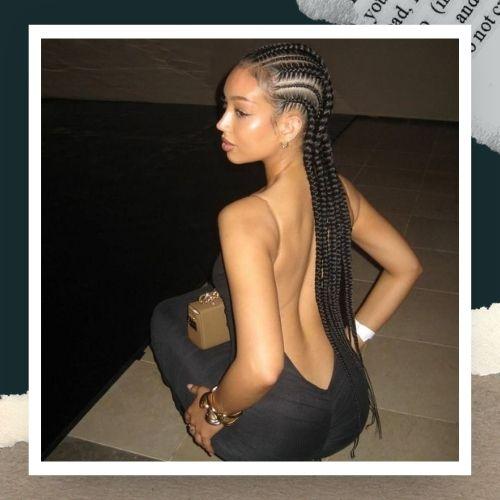 A woman in a backless black outfit featuring classic straight-back cornrow braids.