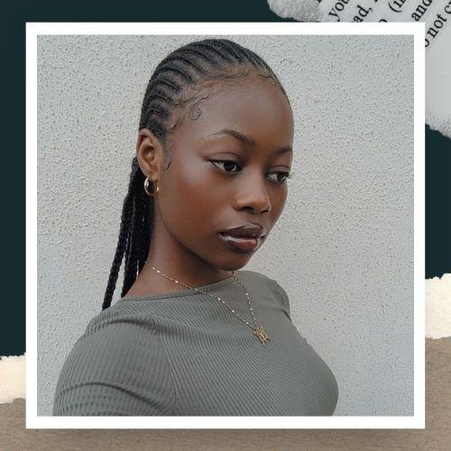 A woman in a grey shirt showcasing very thin, finely braided micro-cornrows.