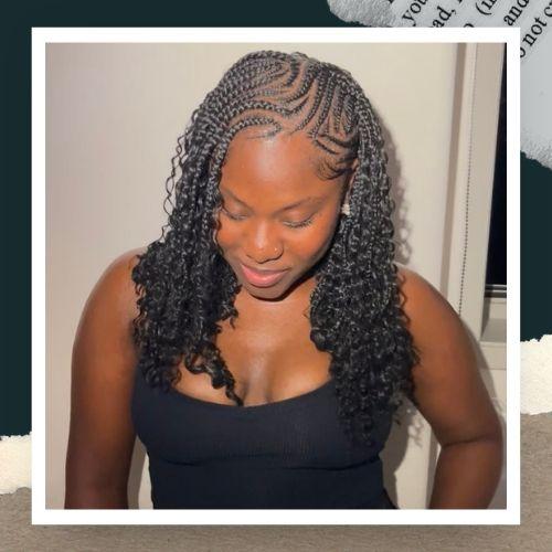 A woman in a black tank top with Fulani-inspired cornrows mixed with curly extensions.