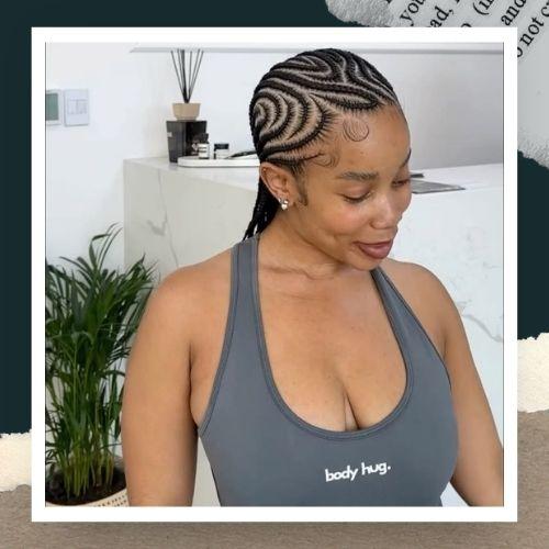 A woman in a grey tank top showcasing patterned geometric cornrow braids.