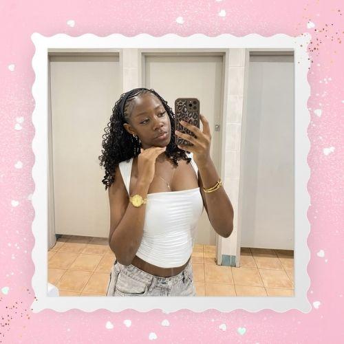 A woman taking a mirror selfie showing half-cornrow half-boho bob braids.