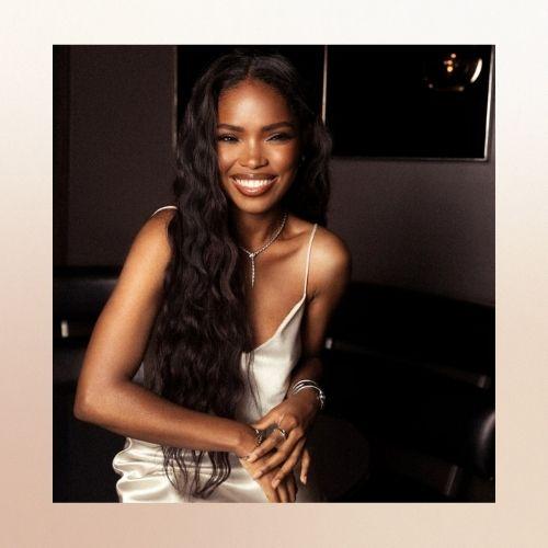 Close-up of Ryan Destiny smiling with long wavy hair.