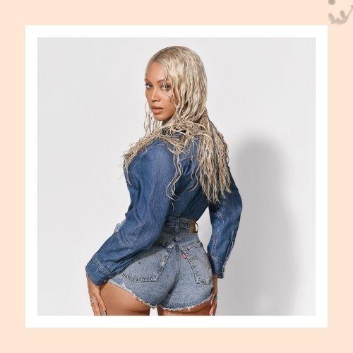 Beyoncé styled with platinum blonde wet-look waves wearing a denim shirt and shorts