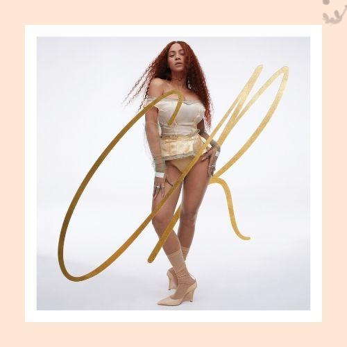 Beyoncé featuring long cinnamon red curly hair in a gold corset outfit